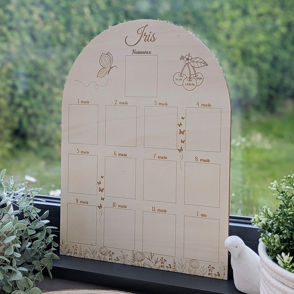 Affiche bébé en bois gravée au laser, posée en extérieur, détail des illustrations et des cases photo